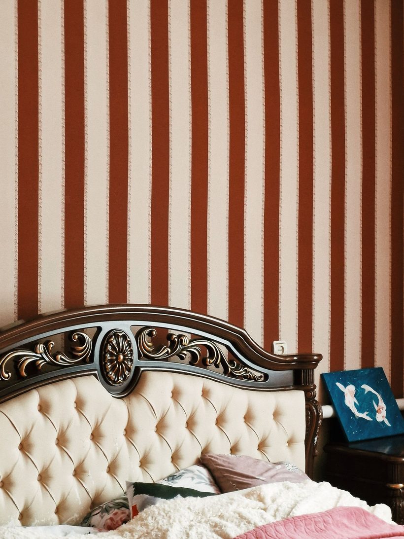 Bedroom with a terracotta striped feature wall and tufted headboard